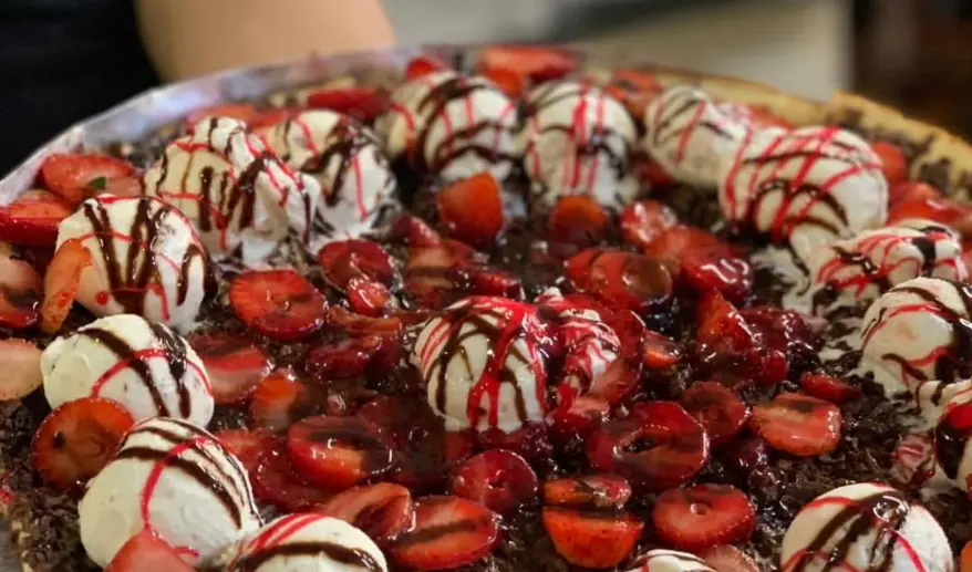 Pizza doce com morangos, sorvete e calda de chocolate