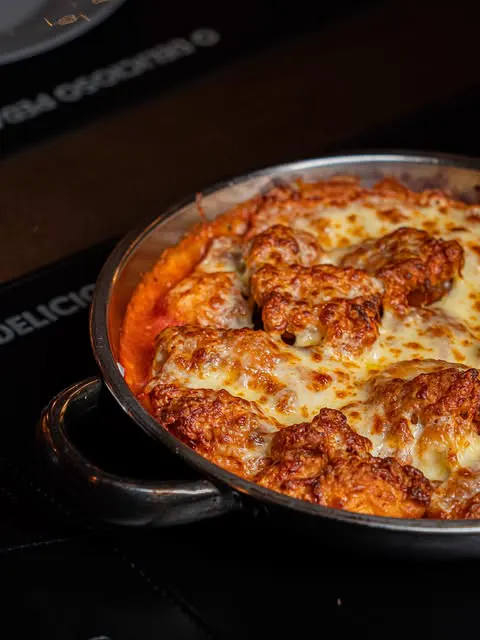 Prato gratinado com muçarela saindo do forno