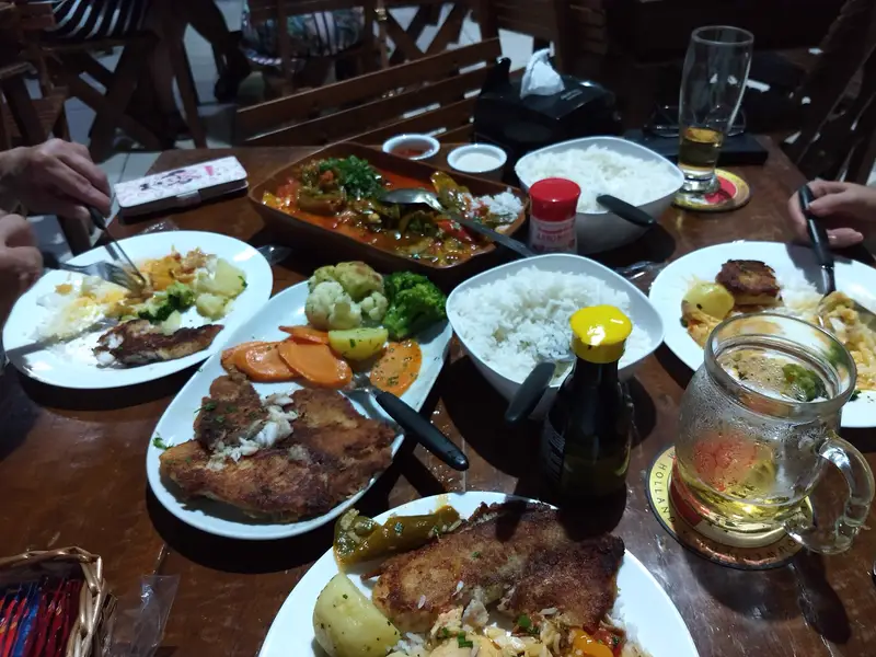 Mesa cheia de pratos e chopp para dividir
